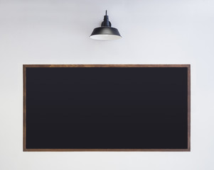 Black Chalkboard on white wall with light Blank Sign menu