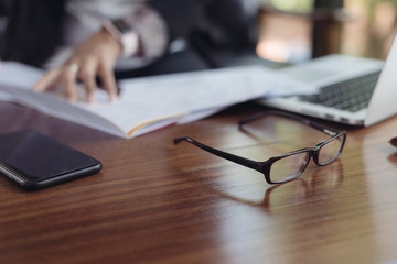 Glasses place on the working desk in selective focus.