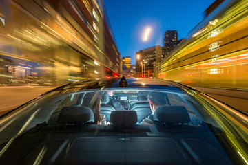 Taxi Driver Riding Couple On City Street At Night