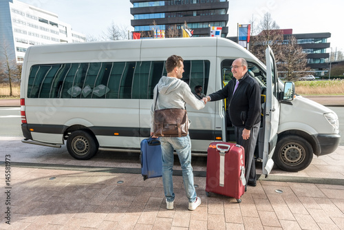 Fotomural Taxi Driver Shaking Hands With Man By Van At Airport