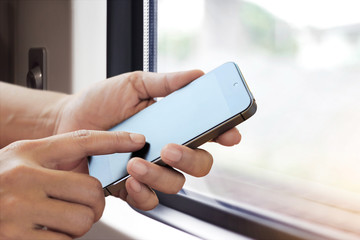 Poster - hands holding smart phone on window of a train background