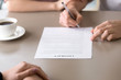 © fizkes - Man signing loan contract for family needs, health insurance for young families, couple agreed to take mortgage to buy apartment flat, close up of male hand putting signature on document