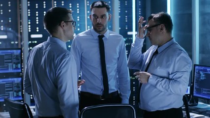 Aufkleber - Three Male Technical Controllers Have Active Discussion in Monitoring Room. System Control Room is full of Working Displays Showing Various Data and Has Servers Racks.