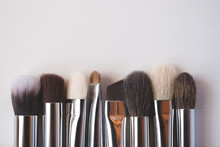 Makeup brushes on wooden background.