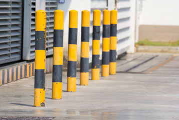 yellow and black steel bollards on concrete floor