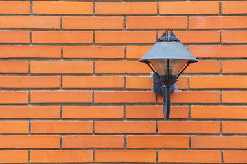 Retro black lamp on red brick wall