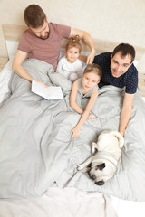 Wall Mural - Male gay couple with children resting in bed at home