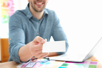 Wall Mural - Handsome young designer with business card in office, closeup