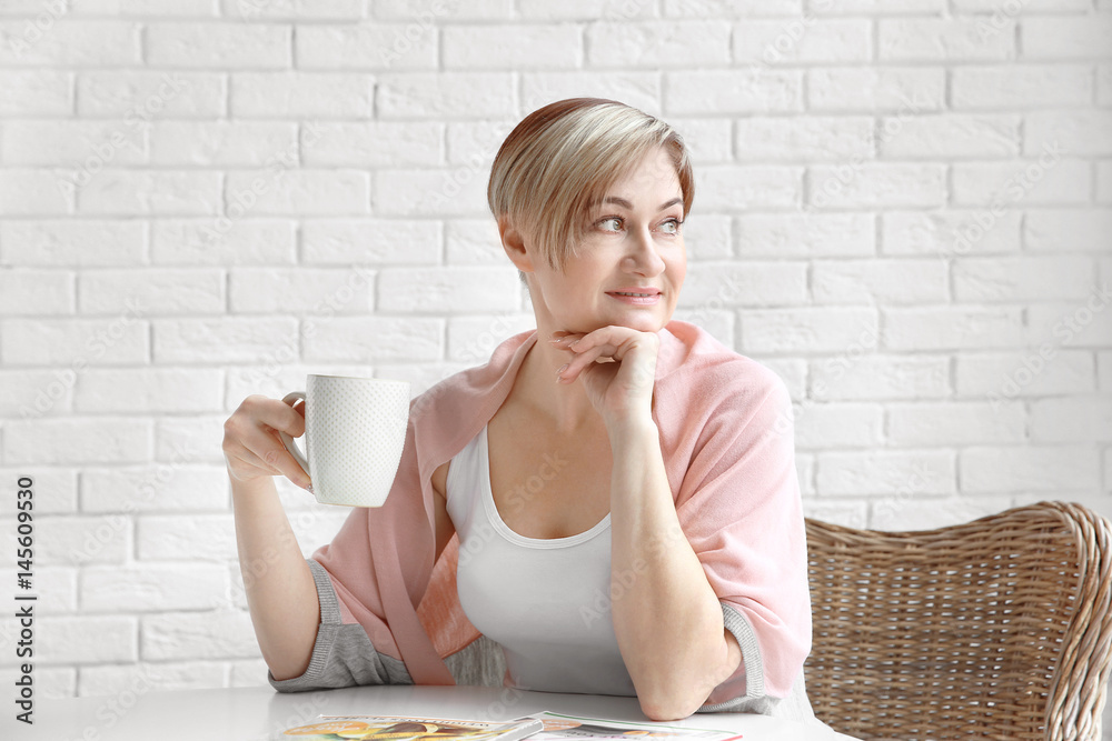 Beautiful mature woman drinking coffee at home