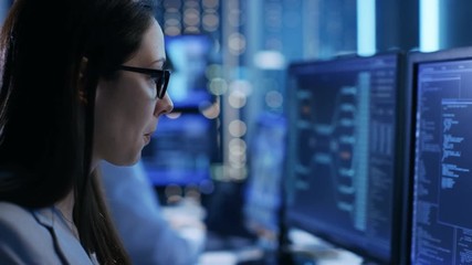 Wall Mural - Close-up Footage of Female IT Engineer Working in Monitoring Room. She Works with Multiple Displays. Shot on RED EPIC-W 8K Helium Cinema Camera.