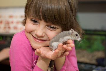 Little girl playing with hamster