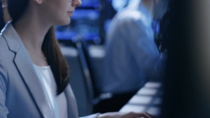 Aufkleber - Close-up Footage of Female IT Engineer Working in Monitoring Room. She Works with Multiple Displays. In The Background Her Colleague Sitting at His Workstation. 