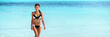 © Maridav - Asian bikini woman with slim body swimming in blue ocean banner of water copy space. Travel holiday girl relaxing on beach vacation.