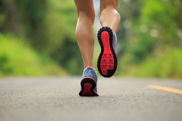 Wall Mural - young fitness woman runner legs running on tropical forest trail