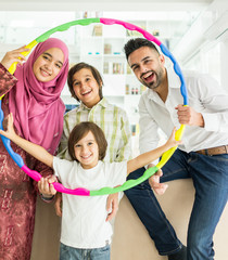 Wall Mural - Happy Arabic Muslim family at modern home having fun and good time together