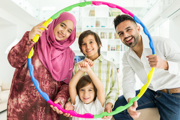 Wall Mural - Happy Arabic Muslim family at modern home having fun and good time together