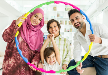 Wall Mural - Happy Arabic Muslim family at modern home having fun and good time together