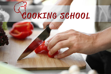 Wall Mural - Male hands cutting red pepper on wooden board closeup