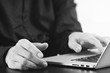 © everythingpossible - close up of businessman hand working with laptop computer in modern office,black and white