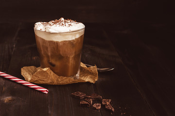 Ice coffee drink with chocolate on the wooden table, with copy space