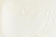 White milk or soy bubble foam background on top view close up