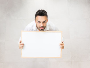 Wall Mural - Young confident man with white board copy space for message or text image