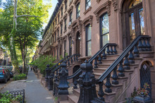 Scenic View Of A Classic Brooklyn Brownstone Block With A Long Facade And Ornate Stoop Balustrades In New York City