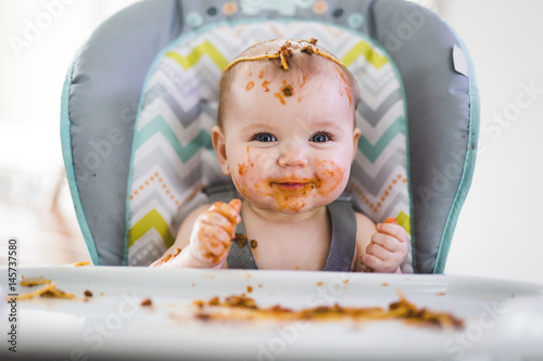 Fotografía Little baby eating her dinner and making a mess