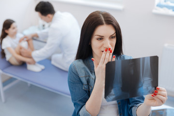 Unhappy worried woman holding an X ray photo