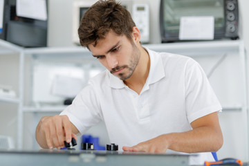 young repairman installing induction cooker in kitchen