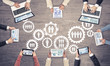 © adam121 - Top view of businesspeople sitting at table and using gadgets