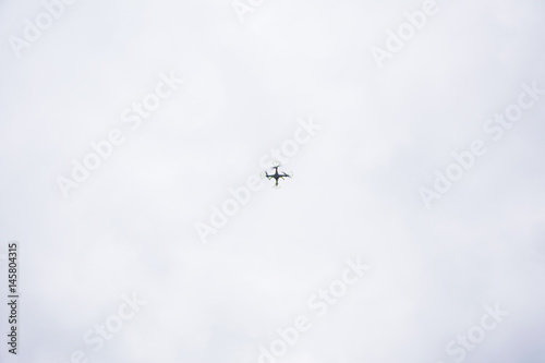 Fotografía white droid flying with a cloudy background