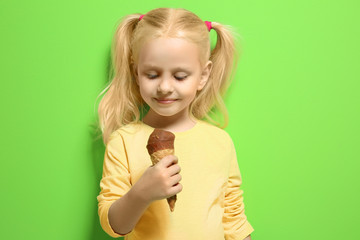 Poster - Cute little girl eating ice cream on color background