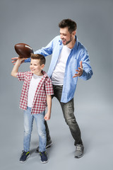 Sticker - Father and son with rugby ball on color background