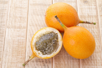 Wall Mural - Granadilla, tropical fruits on wooden background (Passiflora ligularis)