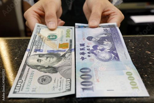 A Teller Poses With U S 100 And New Taiwan Dollar Twd 1000 A Teller Poses With U S 100 And New Taiwan Dollar Twd 1000 Banknotes At