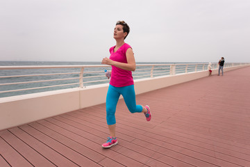 woman busy running on the promenade