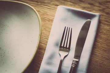 Fork and knife on a table, near a plate