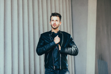 Stylish man in leather clothes posing in the city