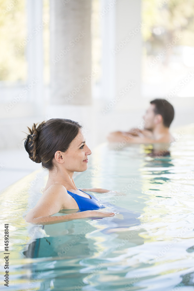 Beautiful brown woman relaxing in thalassotherapy thermal water - obrazy, fototapety, plakaty 