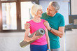 © LIGHTFIELD STUDIOS - Happy old couple with yoga mat in fitness class