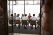 Team in a boardroom meeting seen through open doors, full length