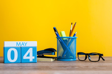 May 4th. Day 4 Of Month, Calendar On Business Office Table, Workplace At Yellow Background. Spring Time