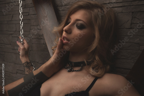 Zdjęcie XXL para grać w gry miłosne. BDSM. kobieta trzymając łańcuchy i całując zrobić palec