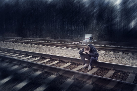 Fototapete - Sad man, sitting on the rails, suicide