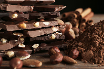 Wall Mural - Chopped chocolate bars with nuts and cocoa powder, closeup