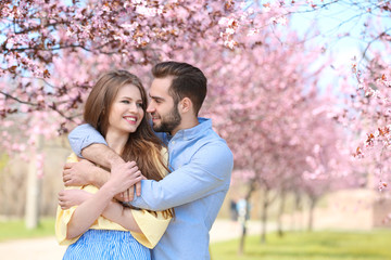 Canvas Print - Young lovely couple walking in spring park