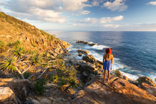 A Young Woman Admires A Coastal View Over The Ocean At Sunrise Near Coffs Harbour, Australia.