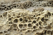 Closeup rock erosion holes sea wall.