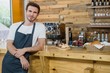 © WavebreakMediaMicro - Portrait of smiling waiter leaning at counter